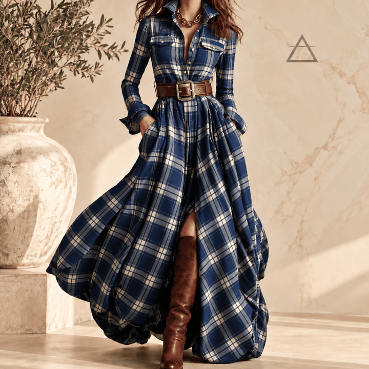 Robe longue Constance en coloris Marine, à carreaux bleu marine et ivoire, portée avec une ceinture brune et des bottes hautes.