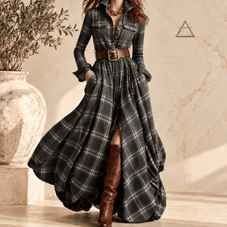 Robe longue Constance en coloris Ardoise, à carreaux gris foncé et gris clair, portée avec une ceinture brune et des bottes hautes.