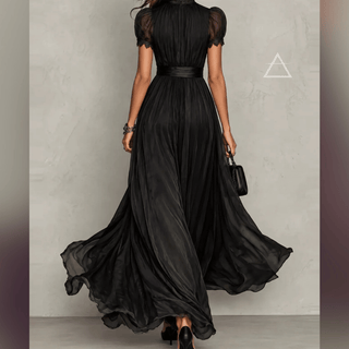 Robe longue Isaline noire portée de dos, avec manches légèrement transparentes.