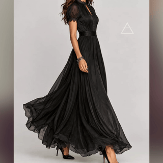 Robe longue Isaline noire portée de profil, avec jupe en mouvement.