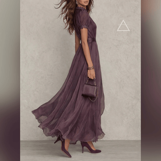 Robe Isaline en violet profond portée de profil, avec manches courtes bouffantes.