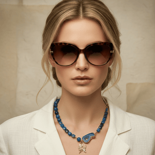 Collier Blue Portal porté avec une veste écrue, montrant son tombé court et son pendentif asymétrique.