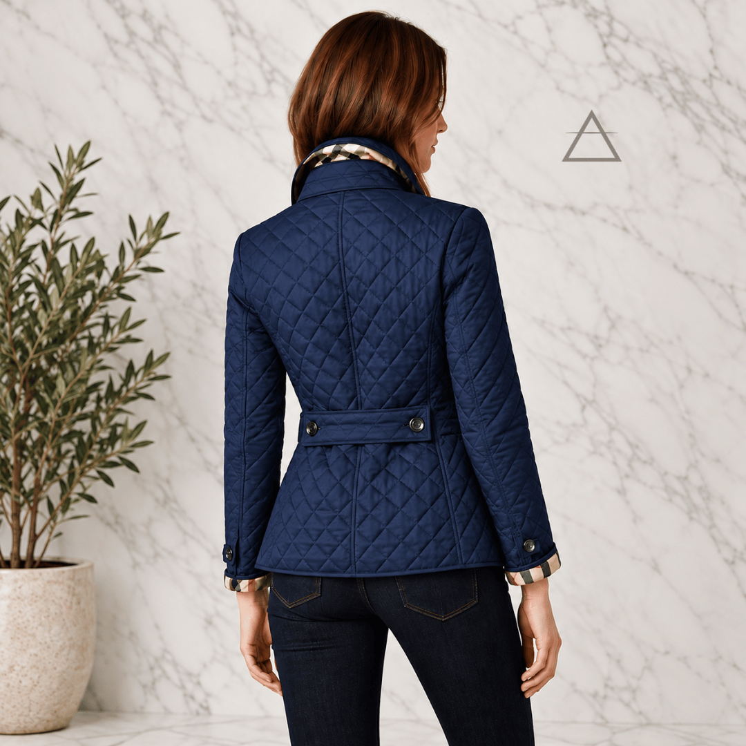 Veste matelassée Margaux en bleu marine, portée de dos, avec matelassage en losanges, patte boutonnée à la taille et revers de poignets à carreaux.
