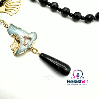 Collier Ocean Midnight détail du pendentif allongé et son élément ajouré doré.
